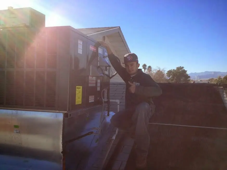 HVAC technician performing AC Tune-Up on a rooftop unit in Bayonet Point